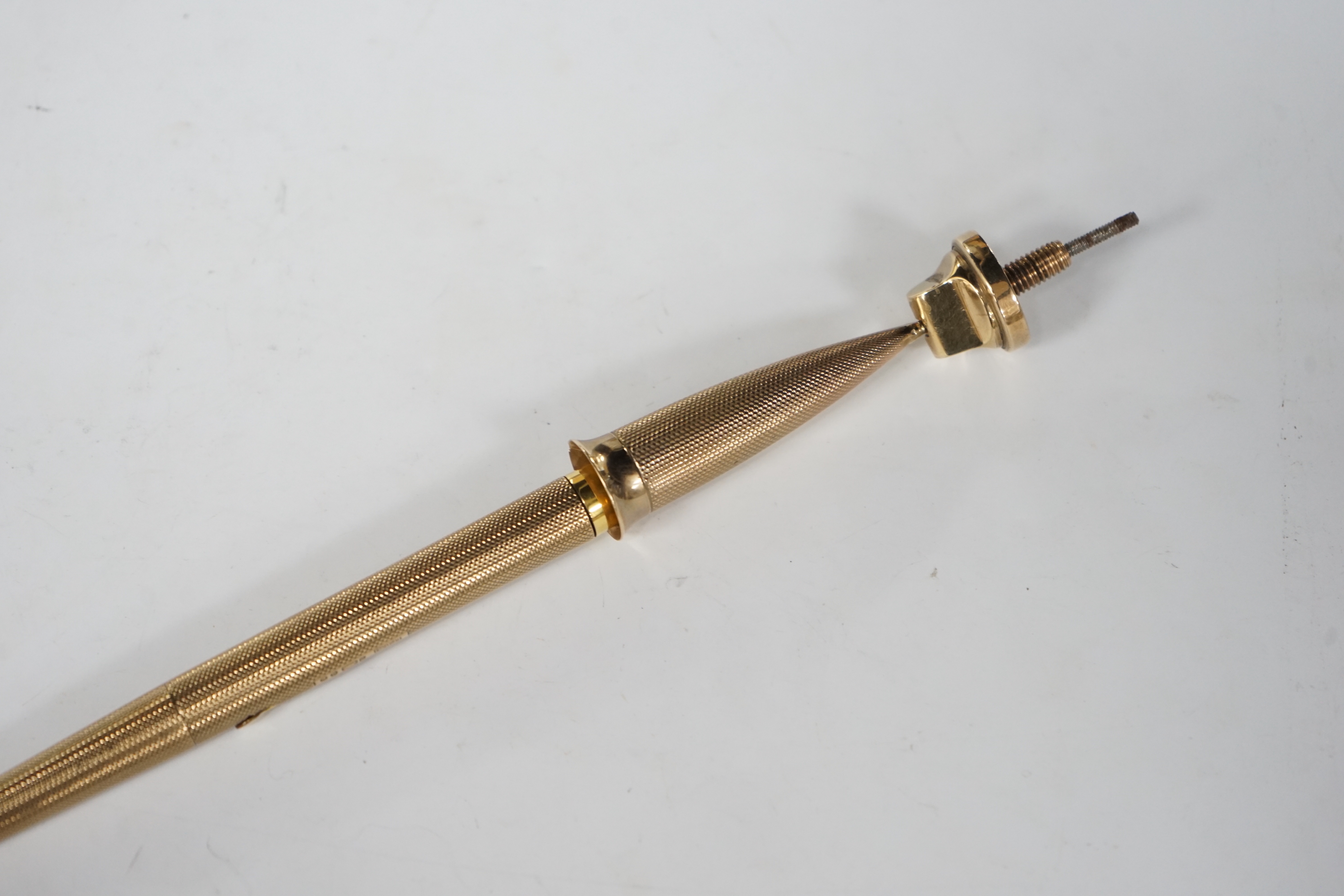 A George V engine turned 9ct. gold combination fountain pen and pencil, with holder (once attached to a stand), maker F.D.W. London, 1935, 20.4cm.